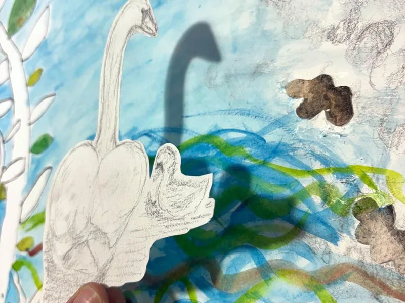 Hand-held swan collage artwork layered over painted background